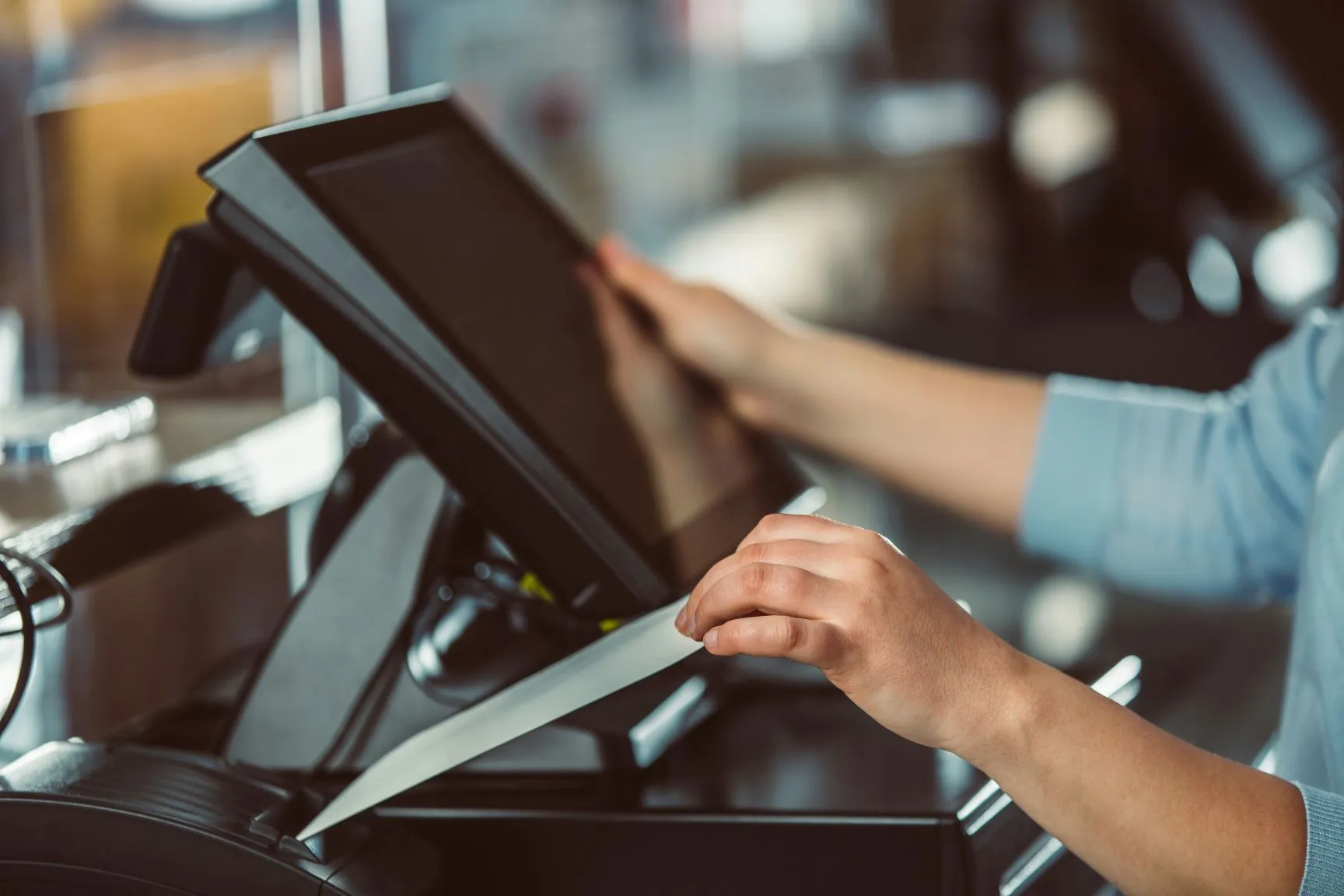 A woman entering something on a point of sale system.